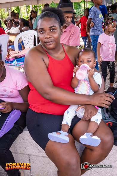 A mother holding her baby at the Forever Summer community outreach