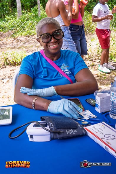 A volunteer nurse at the health screening table during Forever Summer