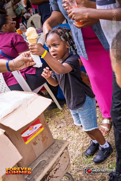 A young girl receiving an ice cream cone at the Forever Summer community event